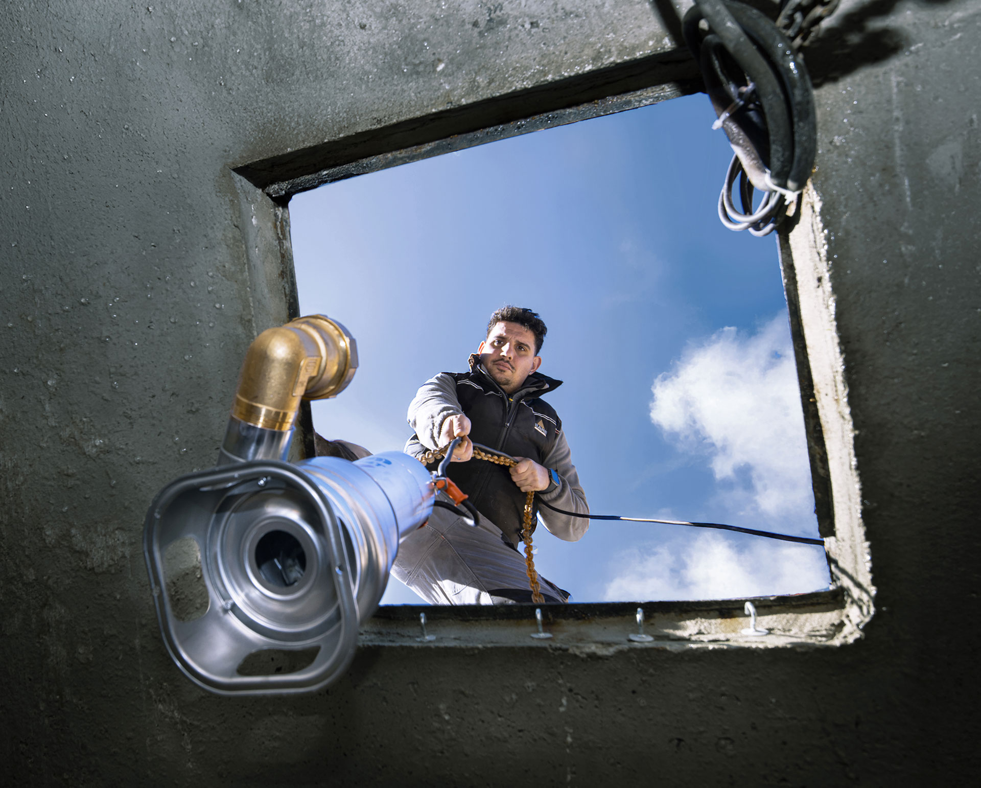 Dipendente RAME al lavoro mentre cala in un tombino impianti di sollevamento acque